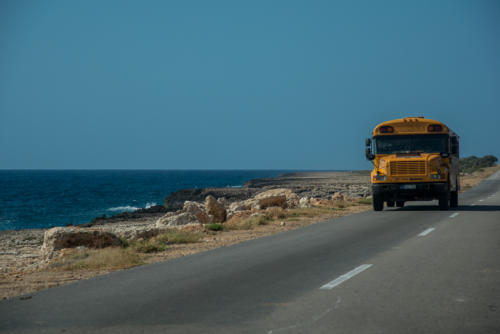 Ols school bus sur la route le long de la mer des Caraïbes
