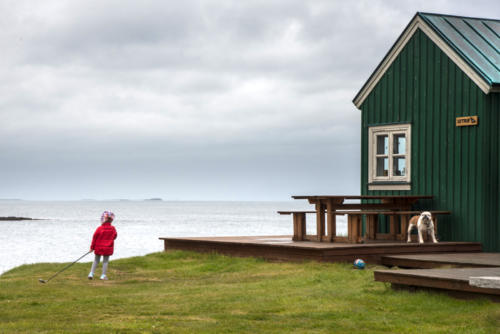 Islande, enfant et chien jouent dehors malgré le mauvais temps