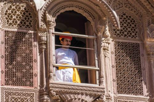 City Palace de Jodhpur : gardien en habit traditionnel derrière les moucharabiehs